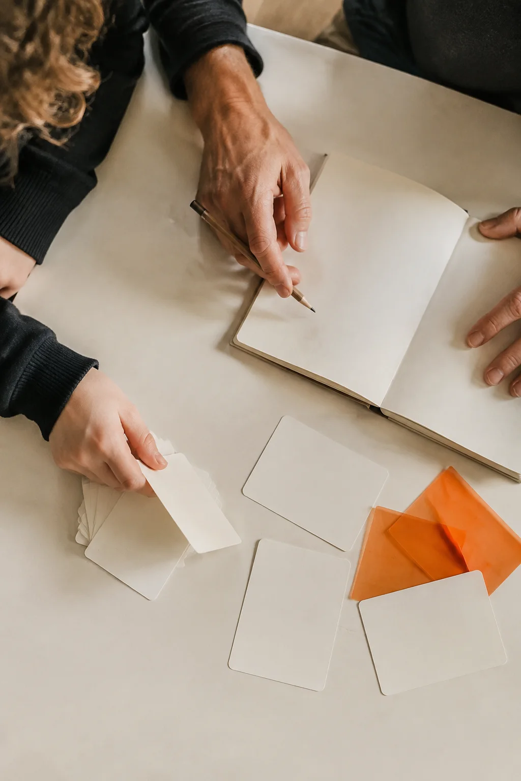 Des mains, un carnet et des cartes pour un travail de réflexion